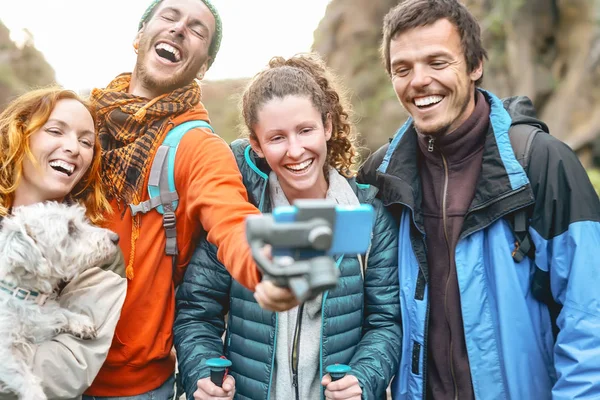 Group friends filming video with gimbal mobile smartphone while trekking mountain - Happy young people having fun with new technology during hike excursion - Travel and tech youth culture concept