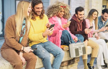 Şehirdeki cep telefonlarını kullanan grup mutlu arkadaşları - Sosyal medya notları için yeni moda uygulamalarla eğlenen Milenyum gençleri - Teknoloji nesli z ve gençlik yaşam tarzı kültür kavramı