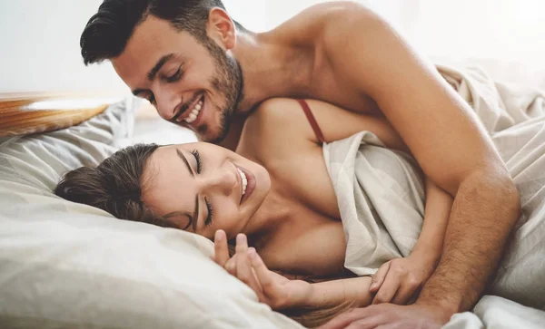 Happy couple having fun on bed under blanket - Young romantic lovers intimate moments - Intimacy and love relationship concept — Stockfoto