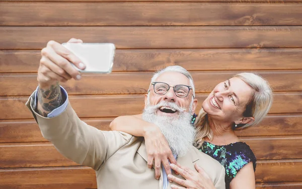 Senioři pár smát a brát selfie s mobilní smartphone kamerou - Sociální starší lidé baví s novou moderní technologií - Tech a starší životní styl aktivity — Stock fotografie