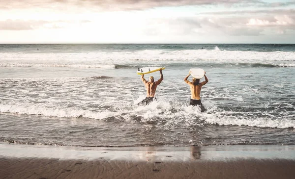 Happy fit vrienden die plezier hebben met surfen bij zonsondergang - Mensen die trainingsoefeningen doen bij schoolsurfers - Sportief gezond lifestyle en extreme sport concept — Stockfoto