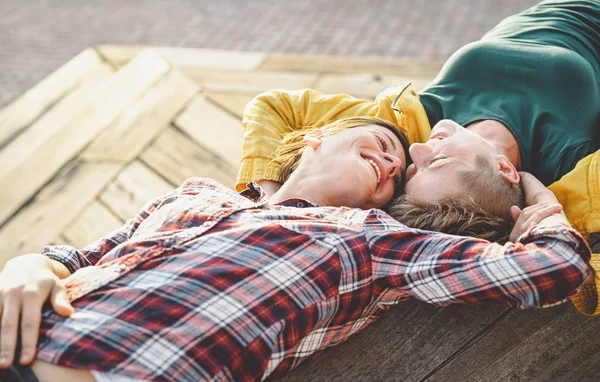 Happy gay couple lying on a bench looking each other - Young lesbian women having a tender romantic moment outdoor - Lgbt homosexuality love and lifestyle relationship concept — Stock Photo, Image