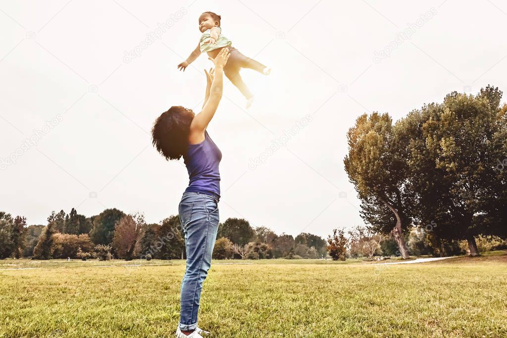 Happy family having fun in park outdoor - Mother and daughter enjoying good time playing together outside - Parents people and positive emotion concept