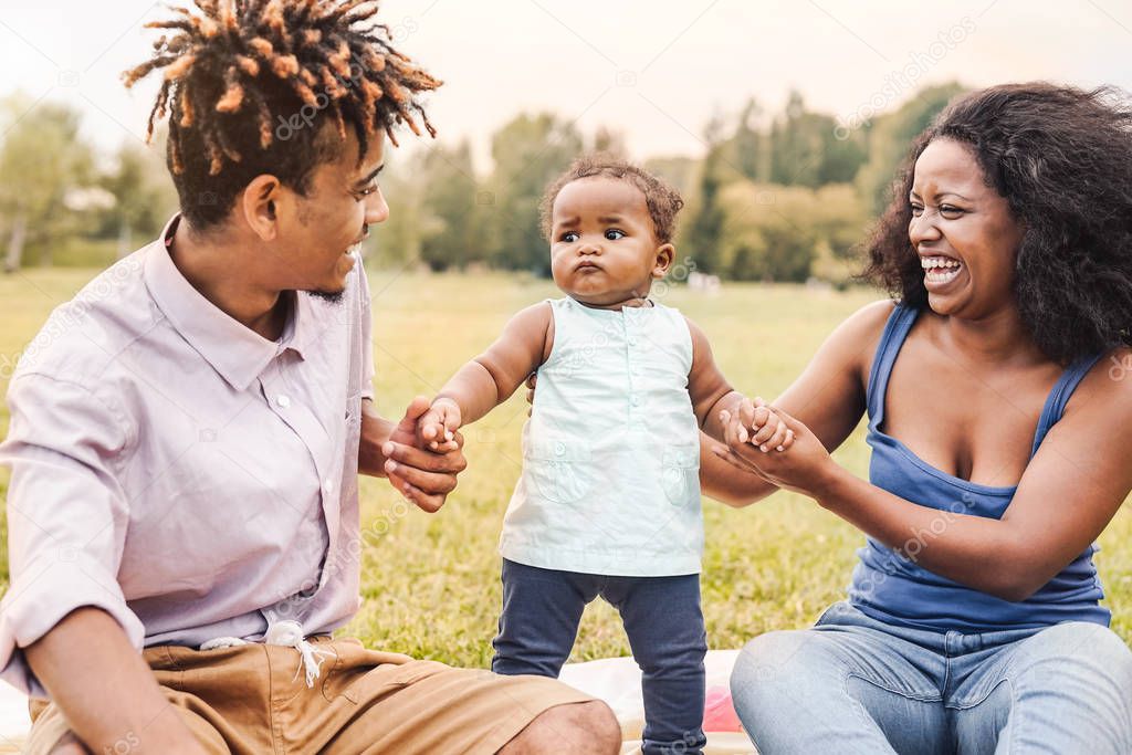 Happy African family having fun together in public park - Black mother father and baby daughter enjoying lovely time outdoor - Happiness, love and parenthood lifestyle concept
