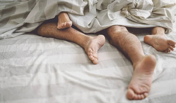 Close up couple feet having sex in bed - Young lovers intimate and passionate moments under white sheets in bedroom - Love relationship and intimacy people concept — Stock Photo, Image