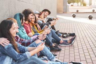 Grup trendleri açık havada akıllı cep telefonları kullanıyor - Milenyum insanları yeni teknoloji trendleriyle eğleniyor Akıllı telefon - Gençlik jenerasyonu yaşam tarzı ve teknoloji bağımlılığı sosyal medya kavramı
