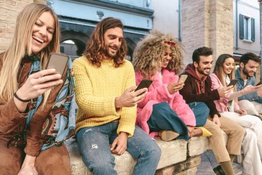 Grup arkadaşları cep telefonlarını açık havada kullanıyor - Sosyal medya telefonu için yeni teknoloji uygulamalarıyla eğlenen trend gençler - Teknoloji ve yeni nesil kültür yaşam tarzı kavramı