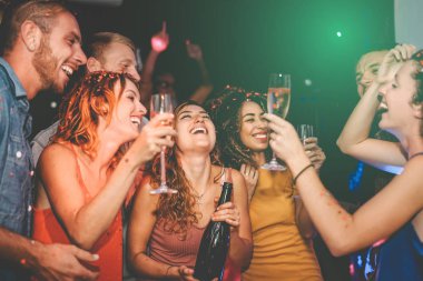 Mutlu arkadaşlar gece kulübünde şampanya içip parti yapıyorlar - Grup gençleri, yeni yıl tatillerini disko kulübünde birlikte kutluyorlar - gençlik kültürü eğlence yaşam tarzı kavramı