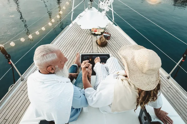 Oudere echtpaar vieren trouwdag op zeilboot - Gelukkig volwassen mensen hebben plezier op boottocht vakantie - Liefde relatie en reizen ouderen levensstijl concept — Stockfoto