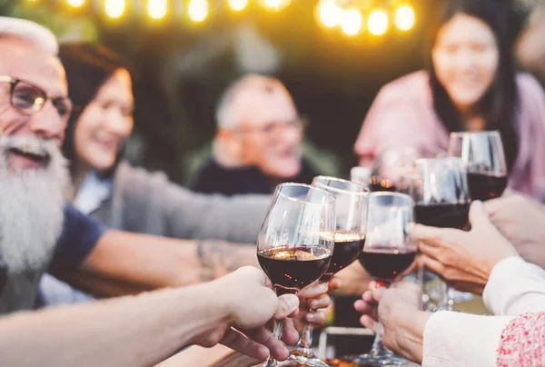 Mutlu aile yemekleri, barbekü partisinde kırmızı şarap kadehleri, birlikte yemek yiyen insanlar, gençlik ve yaşlılar ve hafta sonu aktiviteleri kavramı. — Stok fotoğraf