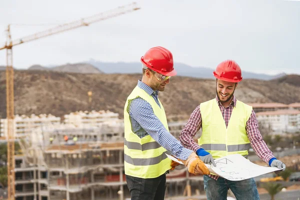 Ingenieros de trabajo discutiendo sobre nueva área de construcción - Jóvenes constructores leyendo el proyecto en el sitio de construcción - Concepto de ingeniería de trabajo en equipo de carpintería —  Fotos de Stock