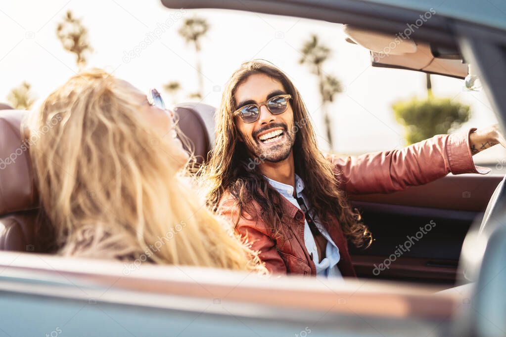 Happy young couple doing road trip in tropical city - Travel people having fun driving in convertible car discovering new places - Relationship and youth vacation lifestyle concept