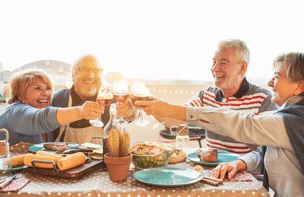 Fröhliches Senioren Essen Und Verkosten Von Rotweingläsern Bei Grillparty Familie — Stockfoto