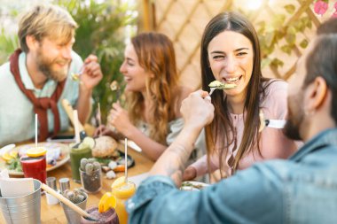 Bar restoranında sağlıklı yiyeceklerle öğle yemeği yiyen mutlu arkadaşlar - brunch yiyen ve smoothies içen gençler - klasik barda taze meyveler - sağlık eğilimleri yaşam tarzı konsepti