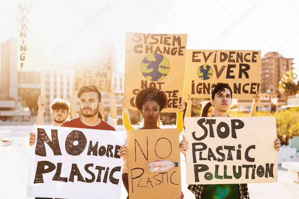 Group demonstrators protesting against plastic pollution and climate change - Multiracial people fighting on road holding banners on environments disasters - Global warming concept