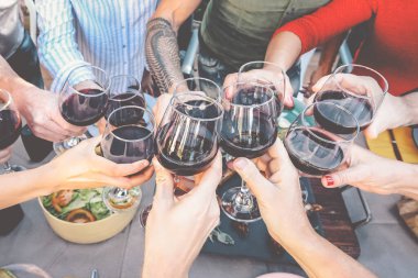 Mutlu aile, akşam yemeğinde kırmızı şarap bardaklarıyla kadeh kaldırıyor insanlar birlikte yemek yerken eğleniyor ve içiyorlar yemek ve içecek hafta sonu yaşam tarzı aktiviteleri.