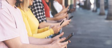 Grup arkadaşları açık havada cep telefonu kullanıyor - Milenyum gençleri yeni teknoloji eğilimlerine bağımlı - Gençlik sosyal nesil yaşam tarzı kavramı