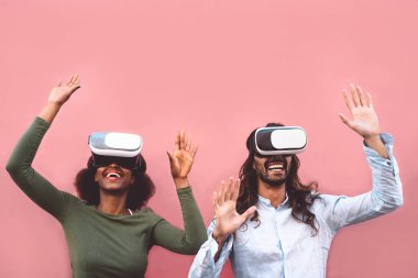 Sanal gerçeklik kulaklığı kullanan mutlu çift - yenilikçi VR Google teknolojisi ile eğlenen trend insanlar - Teknoloji ve 3D oyun deneyimi konsepti
