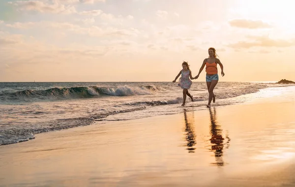 Ευτυχισμένη Στοργική Οικογένεια Μητέρα Και Κόρη Τρέχουν Στην Παραλία Ηλιοβασίλεμα — Φωτογραφία Αρχείου