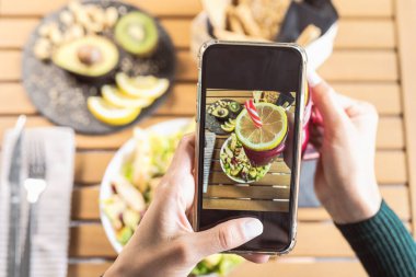 Üst düzey kadın eller cep telefonuyla sağlıklı öğle yemeklerinde fotoğraf çekiyor - genç kişi sosyal medya için yeni teknoloji uygulamalarıyla eğleniyor - sağlıklı insanlar yaşam tarzı ve teknoloji bağımlısı kavram
