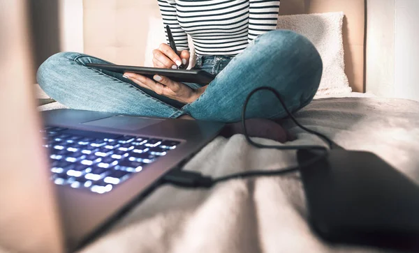 グラフィックデザイナーの女性が自宅でコンピュータ上でスマートな作業 ベッドの中でインタラクティブなペンとラップトップを持つ若い女性の図面 ワイヤレス技術とデザインフリーランスの仕事のライフスタイルのコンセプト — ストック写真