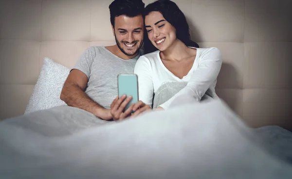 Young Couple Using Mobile Phone Bed Man Woman Watching Smartphone — Stock Photo, Image