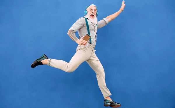 Hombre Loco Mayor Saltando Mientras Escucha Música Con Auriculares Inalámbricos —  Fotos de Stock