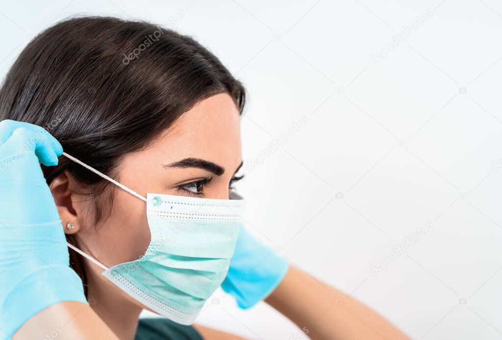 Young woman doctor portrait wearing surgical face mask and gloves - People working for preventing and stop corona virus spread - Healthcare medicine and coronavirus spread concept