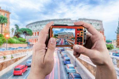 Roma'da Colosseum'un fotoğrafını çeken eller kameraya, İtalya