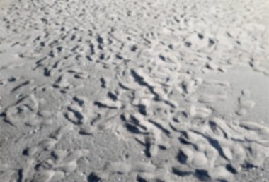 Kumlu bir plaj üzerinde birçok ayak izleri ile ufuk arka plan