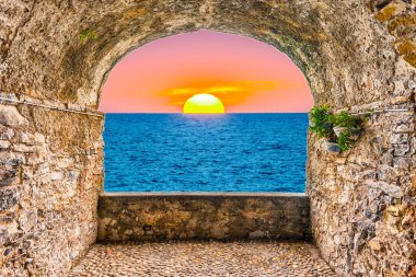 Akdeniz kıyısında gün batımına bakan kaya balkonu, İtalya