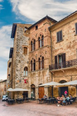 SAN GIMIGNANO, ITALY - 21 Haziran 2019 'da İtalya' nın San Gimignano kentindeki Piazza della Cisterna meydanının manzarası