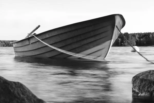 En båt uten passasjerer i havet, bilde i svart-hvitt – stockfoto