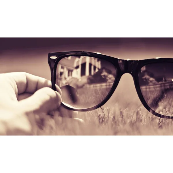 Солнечные очки, удерживаемые одной рукой — стоковое фото