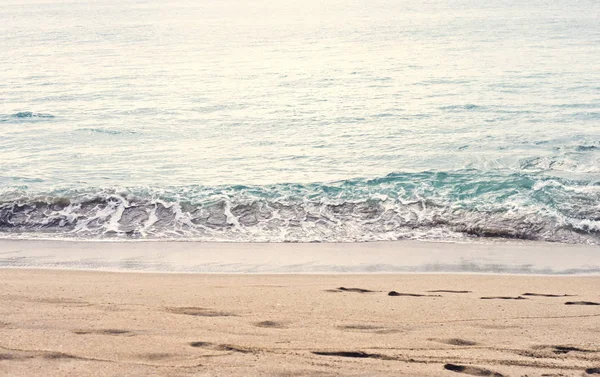 Mooie zomerse seizoen specifieke foto. Rustig strand/kust golven. Rich blauw/turquoise zee/oceaan kleuren. Mooie lampjes en zomer kleuren. Zee en oceaan omgeving in de zomer. Traag bewegende golven — Stockfoto