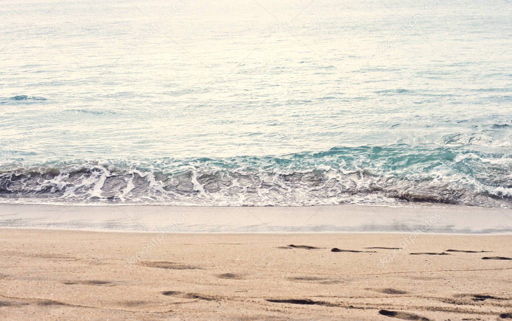 Beautiful summer season specific photograph. Calm beach/shore waves. Rich blue/turquoise marine/ocean colors. Lovely lights and summer colors. Marine and ocean environment in summer. Slow moving waves