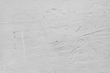 Beyaz duvar arka planı. Beyaz duvarda çizikler, çıkıntılar ve göçükler var..