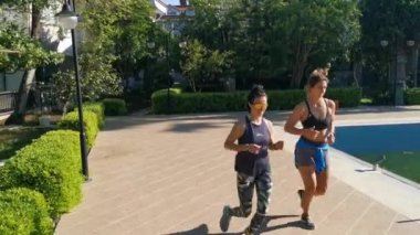 Genç kadınlar mekik çekiyorlar, koşuyorlar, bahçede egzersiz yapıyorlar. Birlikte egzersiz yapıyorlar. Evde kal. Covid 19