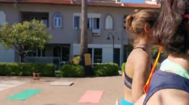 Genç kadınlar mekik çekiyorlar, koşuyorlar, bahçede egzersiz yapıyorlar. Birlikte egzersiz yapıyorlar. Evde kal. Covid 19