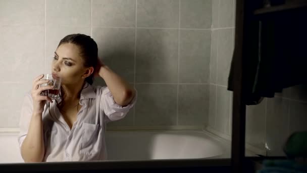 A Young Woman With Wet Hair Is In The Bathtub She Is Holding A Glass With Alcohol In Her Hand And Drinking A Drink