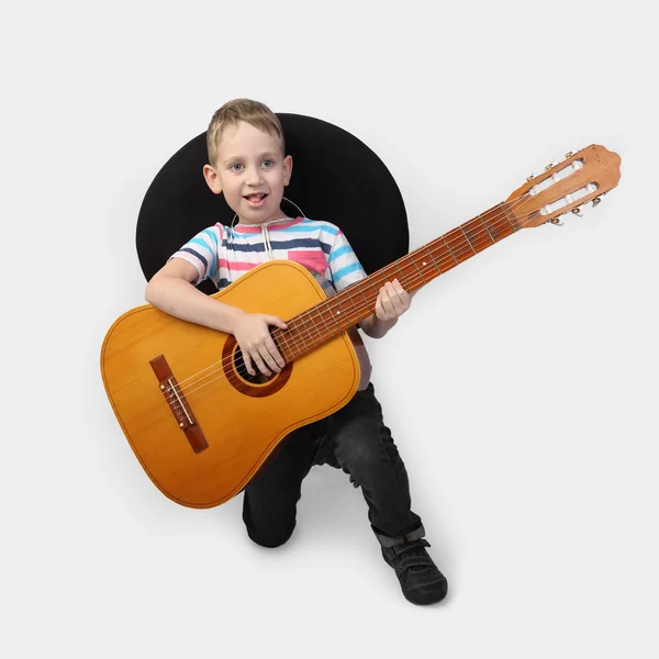 Jongen in sombrero met gitaar op grijs — Stockfoto