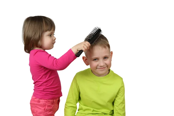 Little girl combs boy hair — Stockfoto