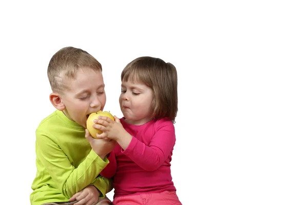 Little girl shares her apple with boy — Stock Photo, Image