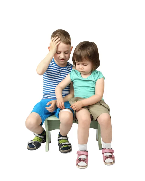 Little girl sticks patch on elder boy knee — Stock Photo, Image