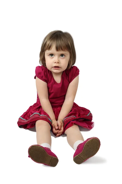 Cute little girl sits on floor — Stock Photo, Image