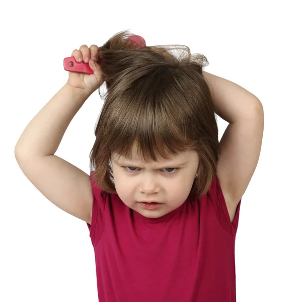 Angry little girl combs her hair — ストック写真