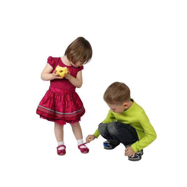 Старший мальчик привязывает обувь к младшей сестринской ноге — стоковое фото