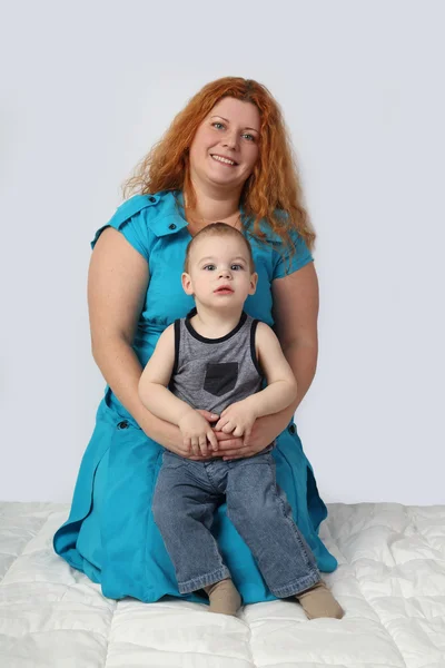 Kızıl saçlı kadın battaniye var küçük oğluyla birlikte oturur. — Stok fotoğraf
