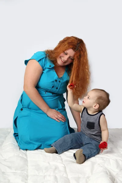 Redhead woman sits on blanket playing with her little son — Stock Photo, Image