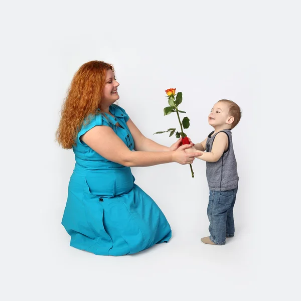 Little boy gives rose to his happy mother — Stock Photo, Image